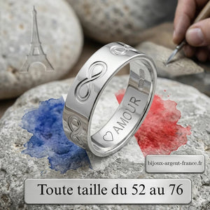Gros plan stylisé d'une alliance en argent rhodié ornée de symboles de l'infini gravés sur tout le tour de l'anneau.