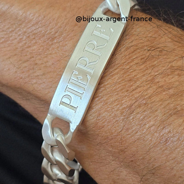 Photo rapprochée d'une Gourmette Homme XXL en Argent Massif 14mm maille cubaine avec plaque gravée "PIERRE" portée au poignet. Fabrication française artisanale jusqu'à 31cm.