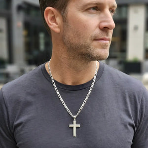 Homme portant un pendentif croix en argent massif sur une chaîne, idéal pour un style moderne et affirmé.