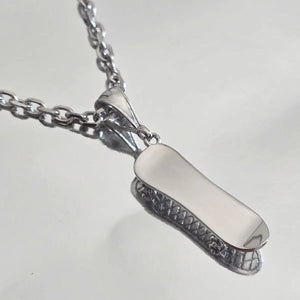 Pendentif skate en Argent rhodié porté sur une chaîne Forçat diamantée 3 mm.