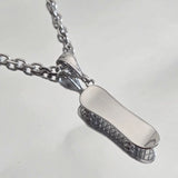 Pendentif skate en Argent rhodié porté sur une chaîne Forçat diamantée 3 mm.